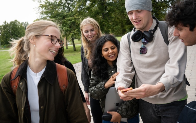 En grupp studenter tittar på en telefon
