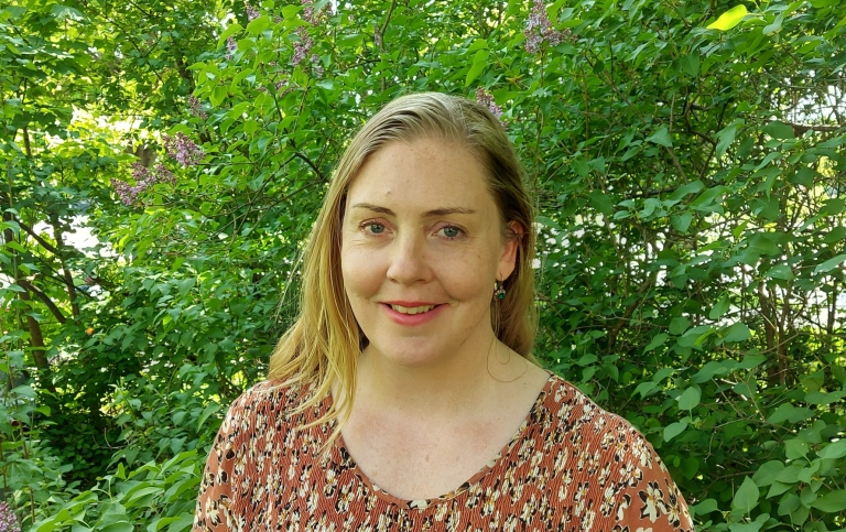 Caroline Eriksson framför en syrénhäck.