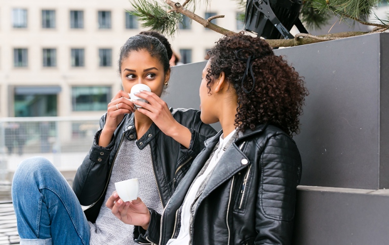 Two young women having a coffee in the city.