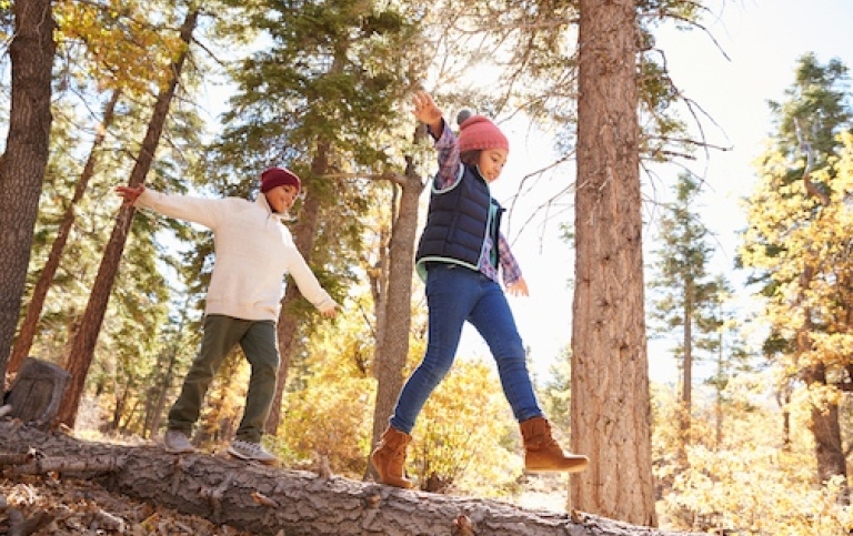 Two siblings playing i the woods