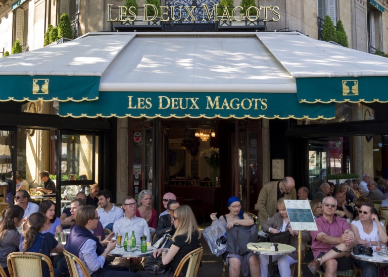 Bild på människor som sitter på utomhusservering i Paris.