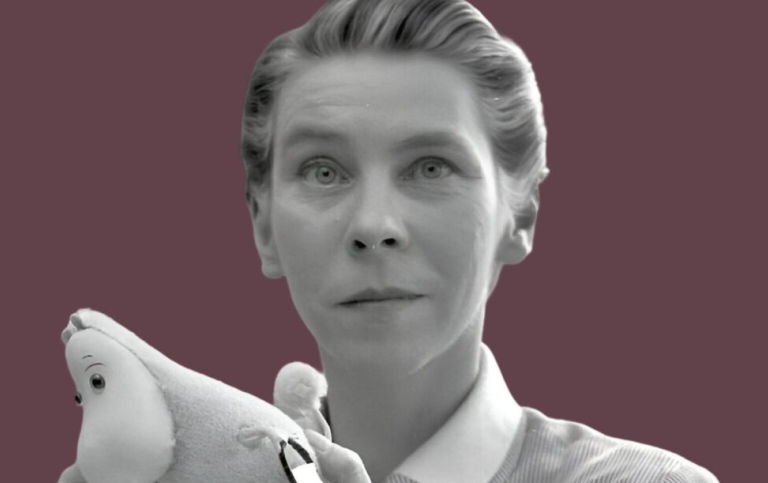 Svartvitt foto på Tove Jansson. Hon har ett mumintroll i famnen.