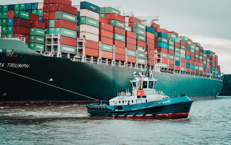 Small tug boat and big container ship.