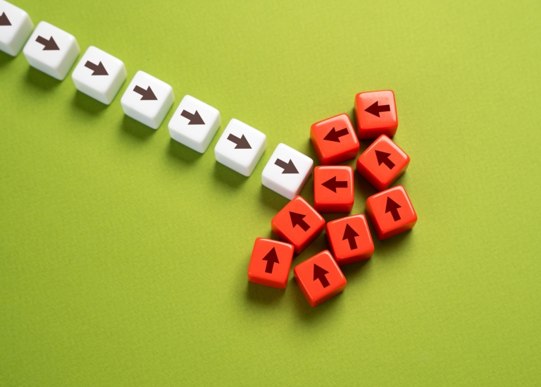 Illustration of white and red dice with a black arrow, symbolizing opposition to progress.