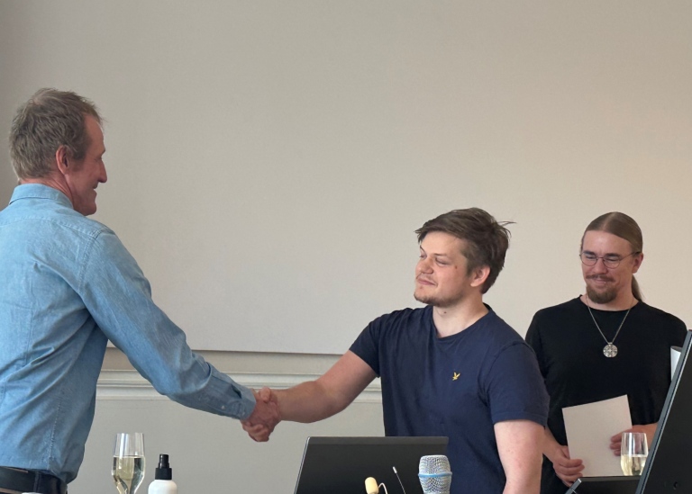 Studierektor Fredrik Hellberg delar ut diplom till studenter