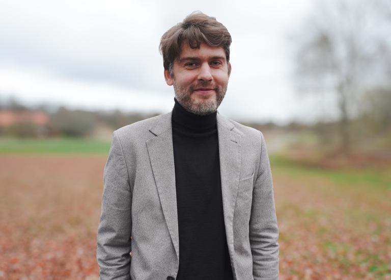 Portrait photo of Krzysztof Czarnecki, outdoors, smiling