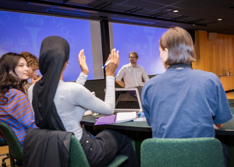 Fyra studenter sitter í ett modernt föreläsningsrum