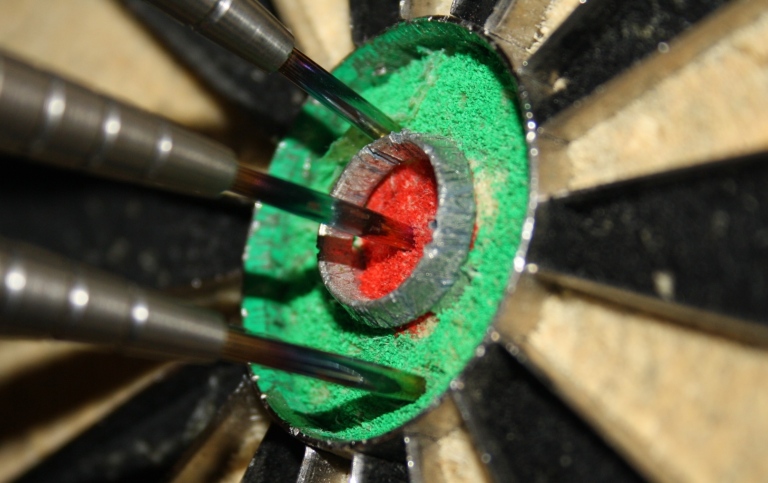 Genre photo of several darts hitting bull's eye