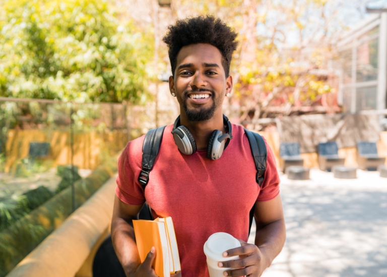 Happy student holding his books.