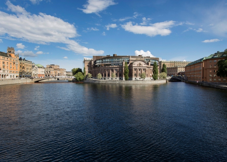 Västra riksdagshuset speglas i Strömmen
