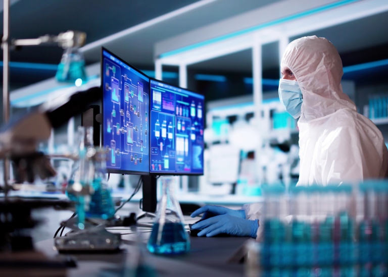 Person in lab clothes sitting in a modern laboratory