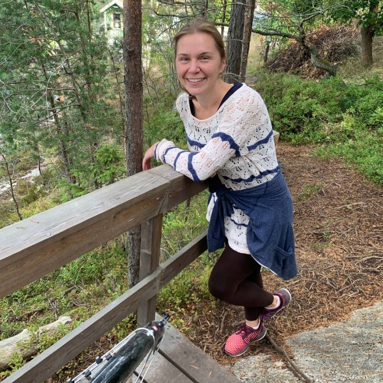 Yulia Kashevarova i skogen lutar sig mot ett trappräcke