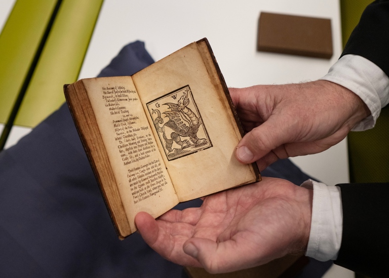 Liten bok som är uppslagen ryms i rar-bibliotekarien Tommy Westergrens händer.