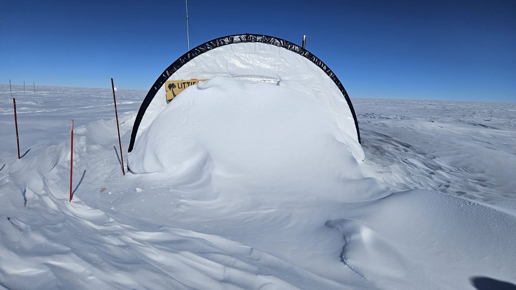 A research dome partially covered with snow.