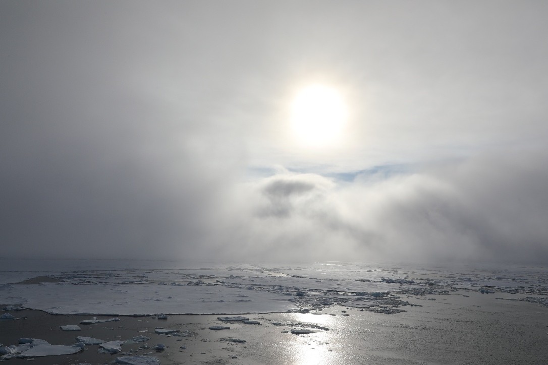 Caption: Sun appearing behind thick clouds.