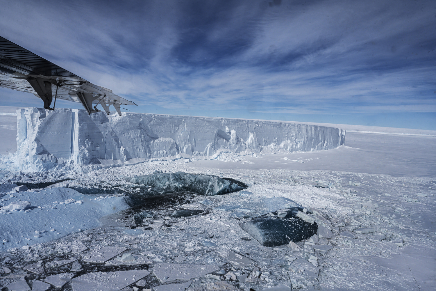 The edge of a large ice shelf in Antarctica. The photo is taken from a small airplane