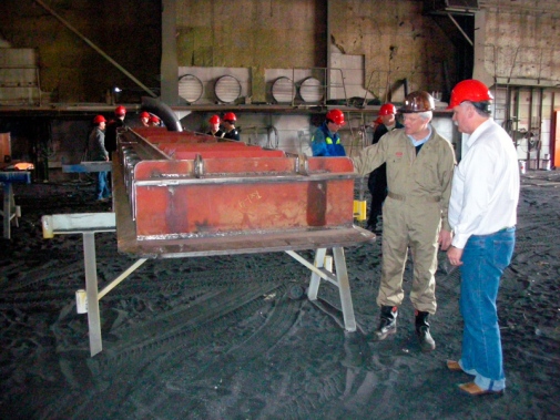 Two men talking beside the steel frame