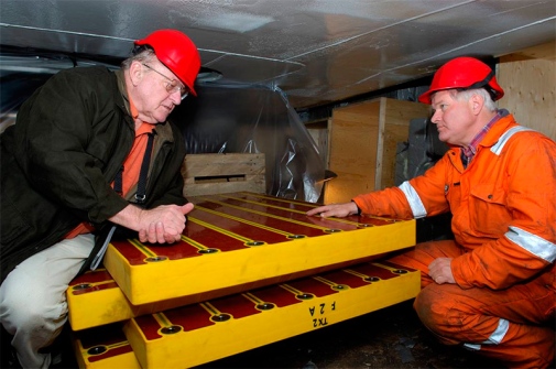 Two men leaning on to frame like objects, yellow and red