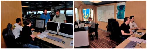 people sitting in front of computers and some standing behing screens
