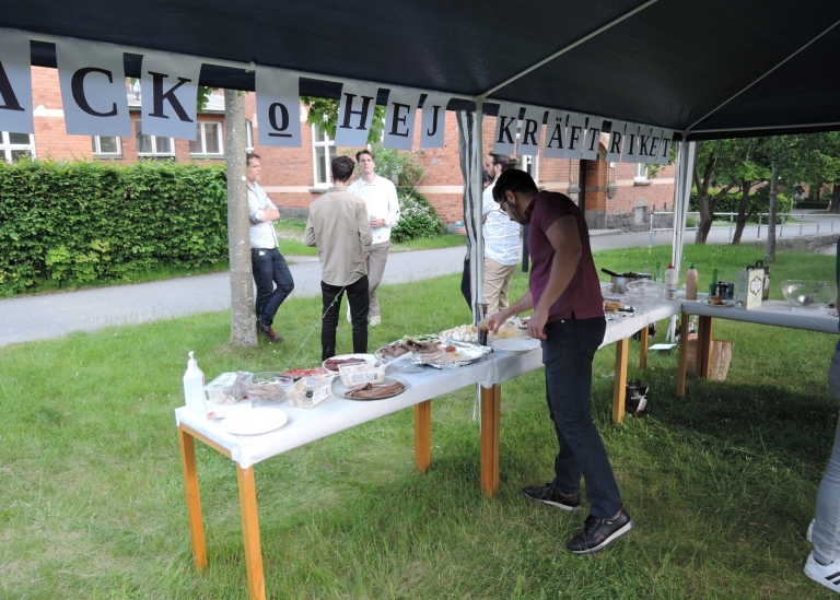 Buffébord under partytält. På skylt på tältet står "Tack o hej Kräftriket"