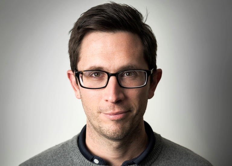 Daniel Martinez Molina. He has dark hair, glasses and is wearing a grey sweater.