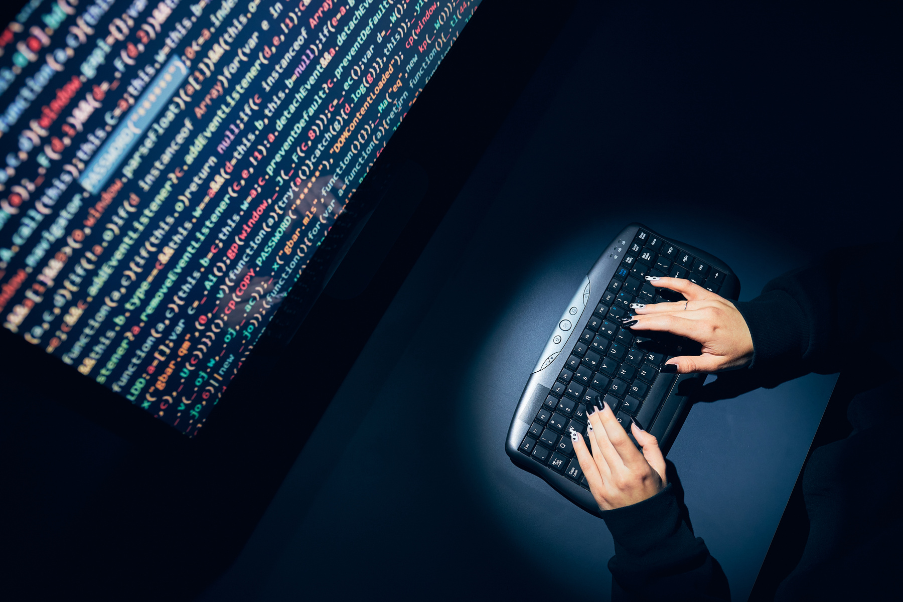 hands typing on keyboard in front of computer screen