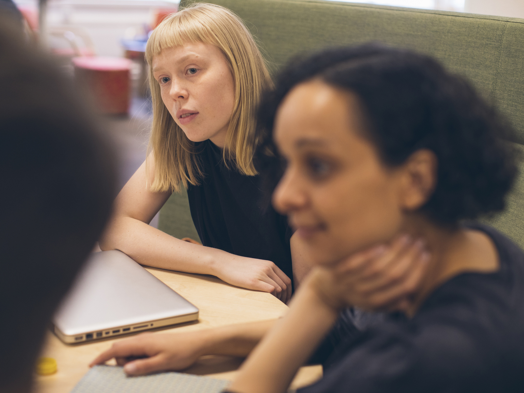 Studenter sitter runt bord och samtalar