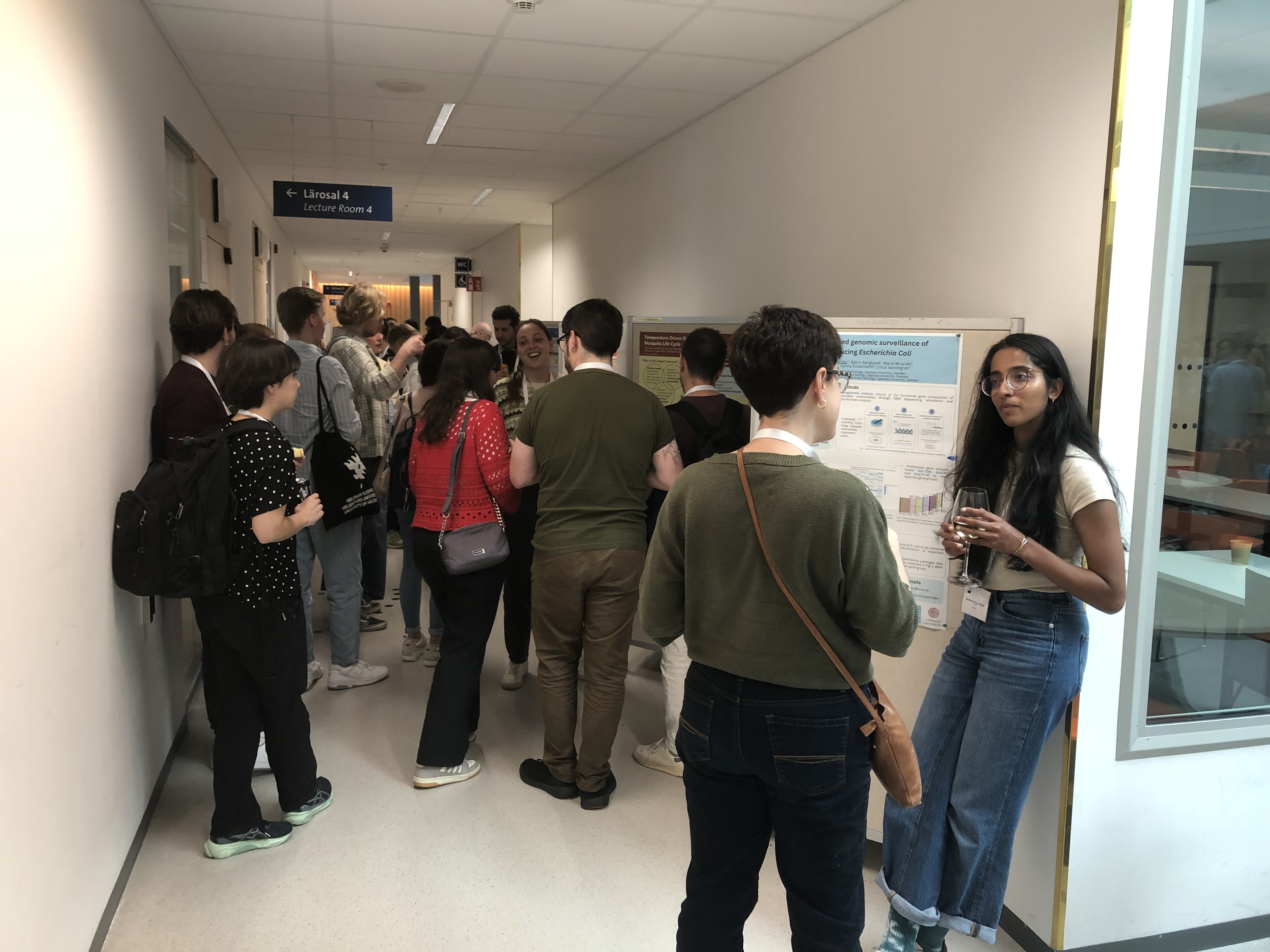 Corridor, people looking at scientific posters.