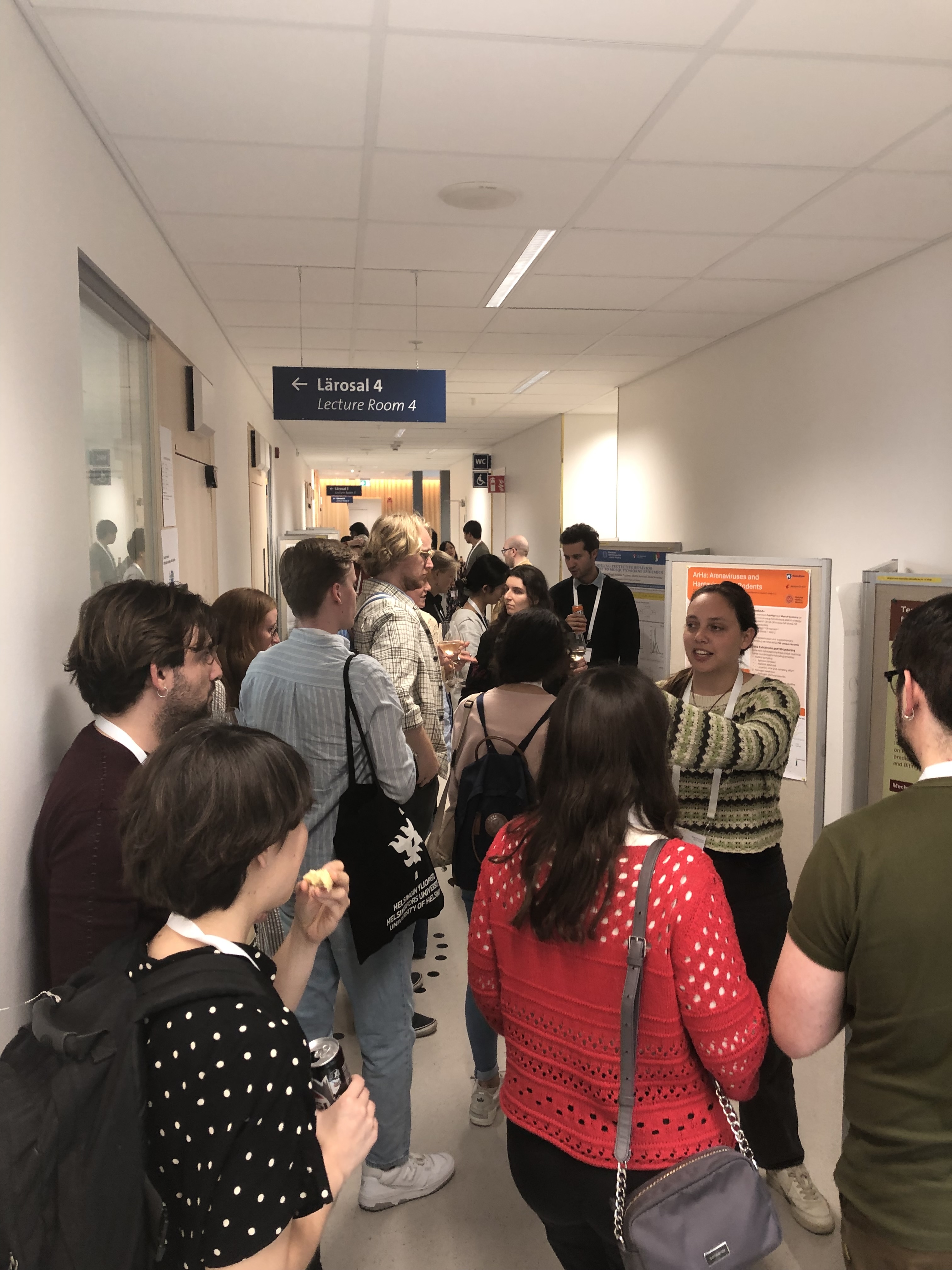 Corridor, people looking at scientific posters.