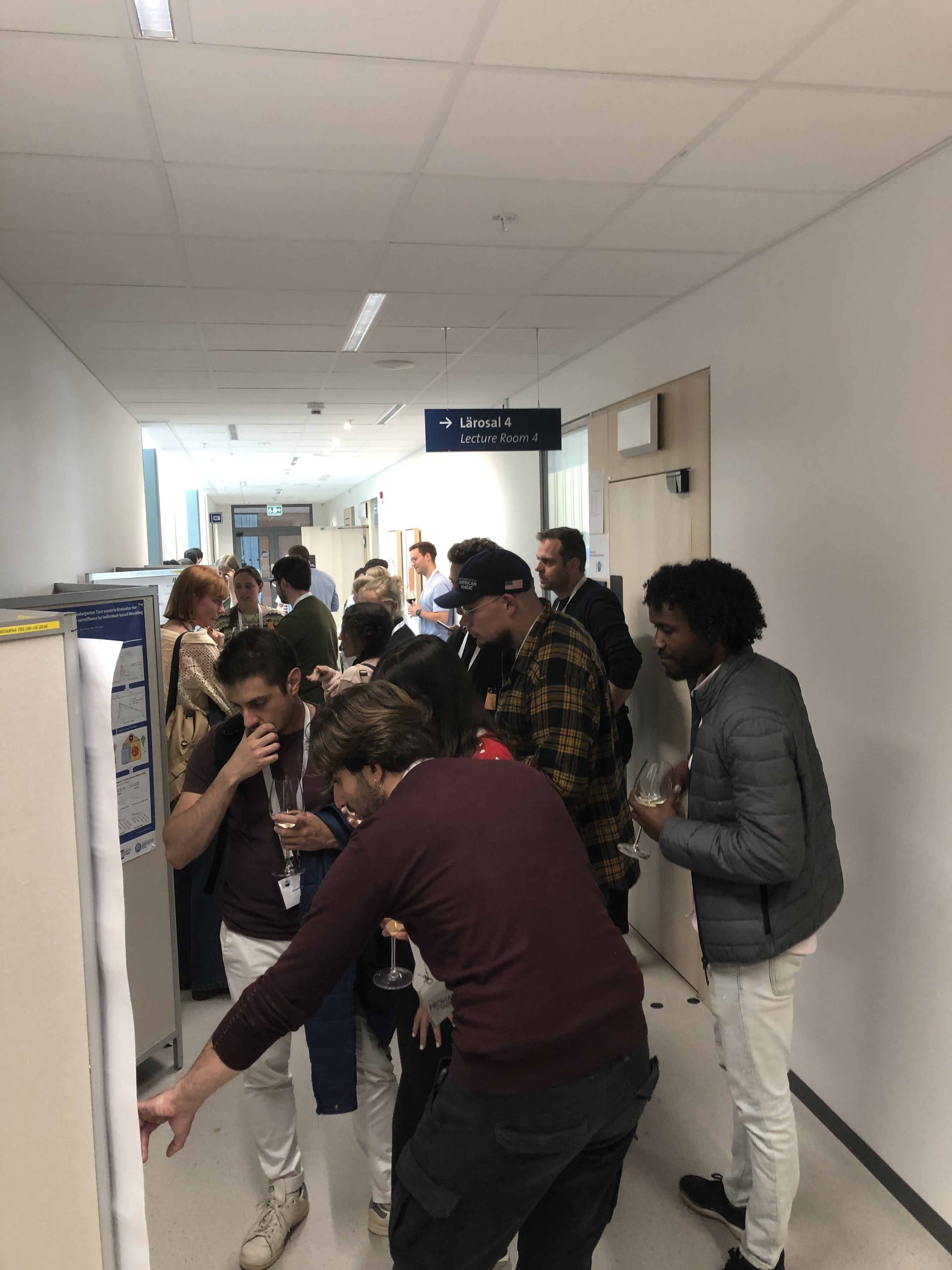 Corridor, people looking at scientific posters.