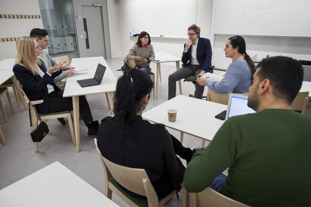 Studenter diskuterar i två grupper, i en lärosal i Albano.