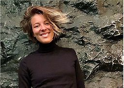 Sanna fotograferad mot en bergliknande bakgrund.