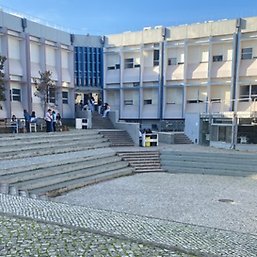 En bild på campus med en dator i förgrunden.