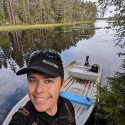Ludvig har keps och han står vid en båt