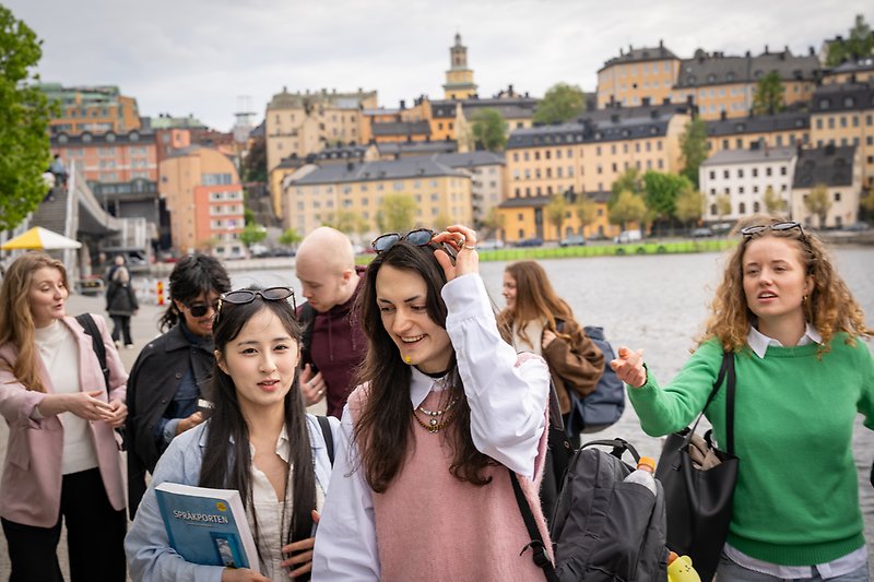 Studenter går inne i stan med Saltsjön och Södermalm i bakgrunden.