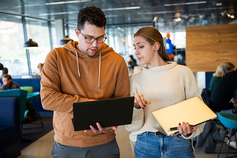 Två studenter med datorer.
