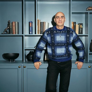 Saeid står framför en bokhylla.