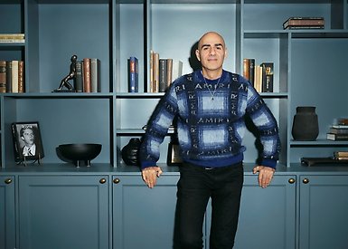Saeid står framför en bokhylla.