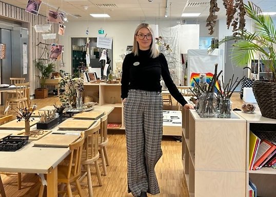 Elin står i en miljö där barnen kan skapa med naturmaterial