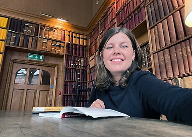 Johanna Wallin läser bok i bibliotek vid Oxford universitet.