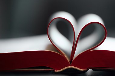 Sidor i en uppslagen bok som formas till ett hjärta.