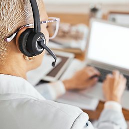 senior woman at laptop with headphones