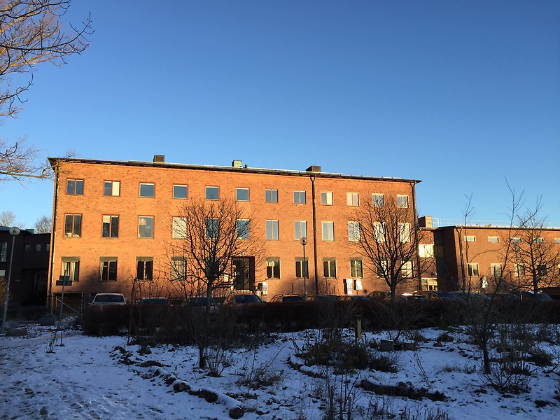 Brown brick building with three floors.