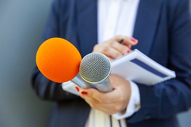 Person with microphones and notepads.