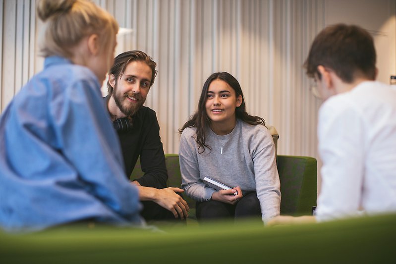 Studenter diskuterar på soffa.