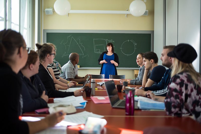 Students and teacher in seminar room.