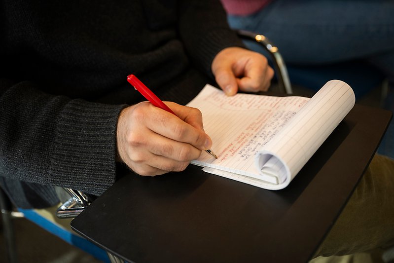 Person writing on notepad.