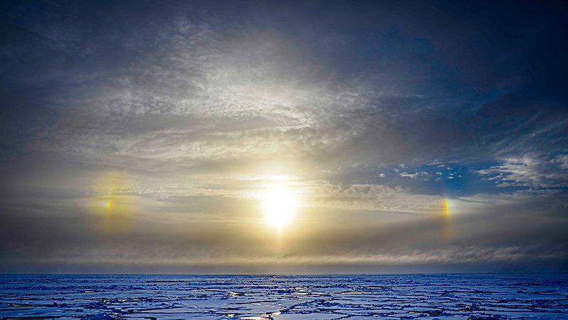 solen, två bisolar, moln och is.
