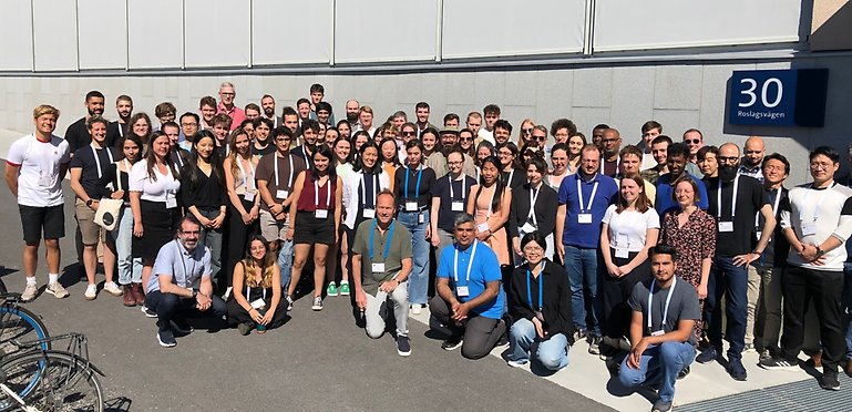Group photo of about 50 people, outside in the sun.