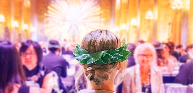 Woman seen from behind at banquet, wearing a bearing wreath.